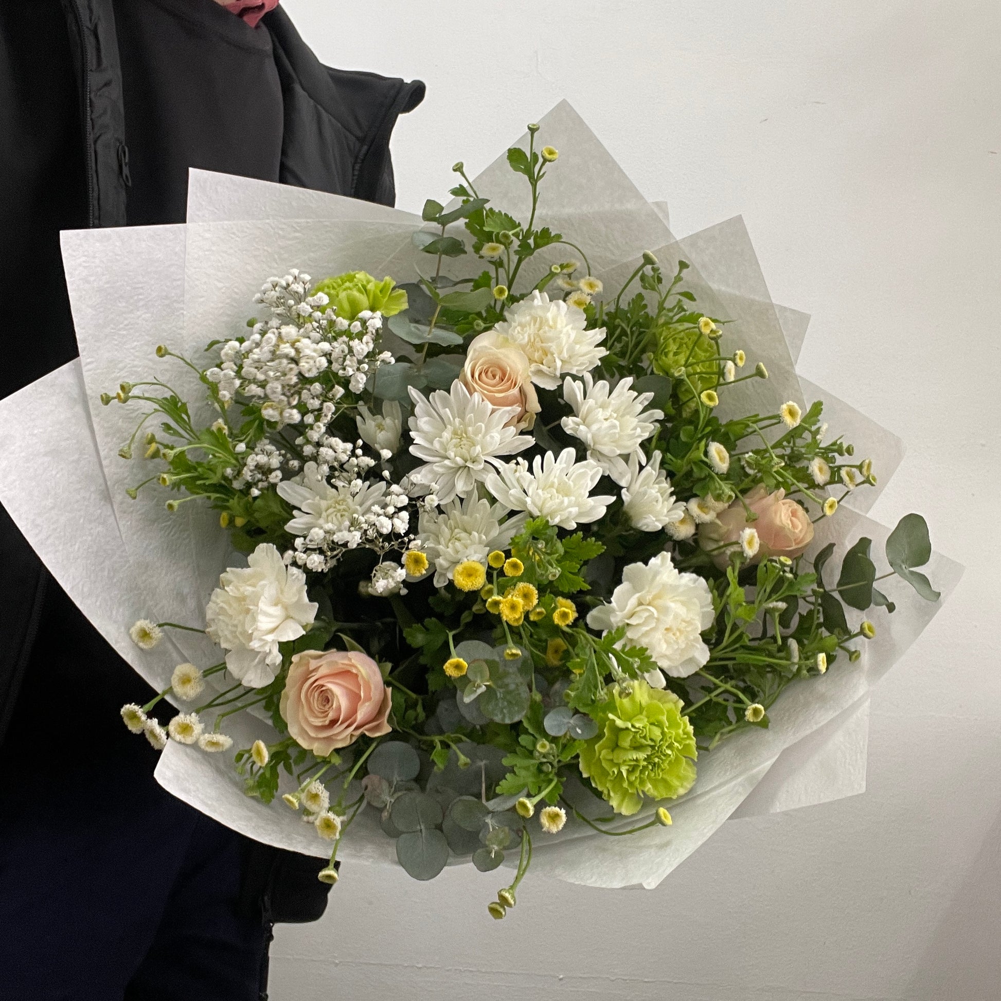 Rounded white, green, and blush pink bouquet featuring roses, chrysanthemums, chamomile, carnations, baby’s breath, and eucalyptus, made by Adam The Flower Man in Sandringham.