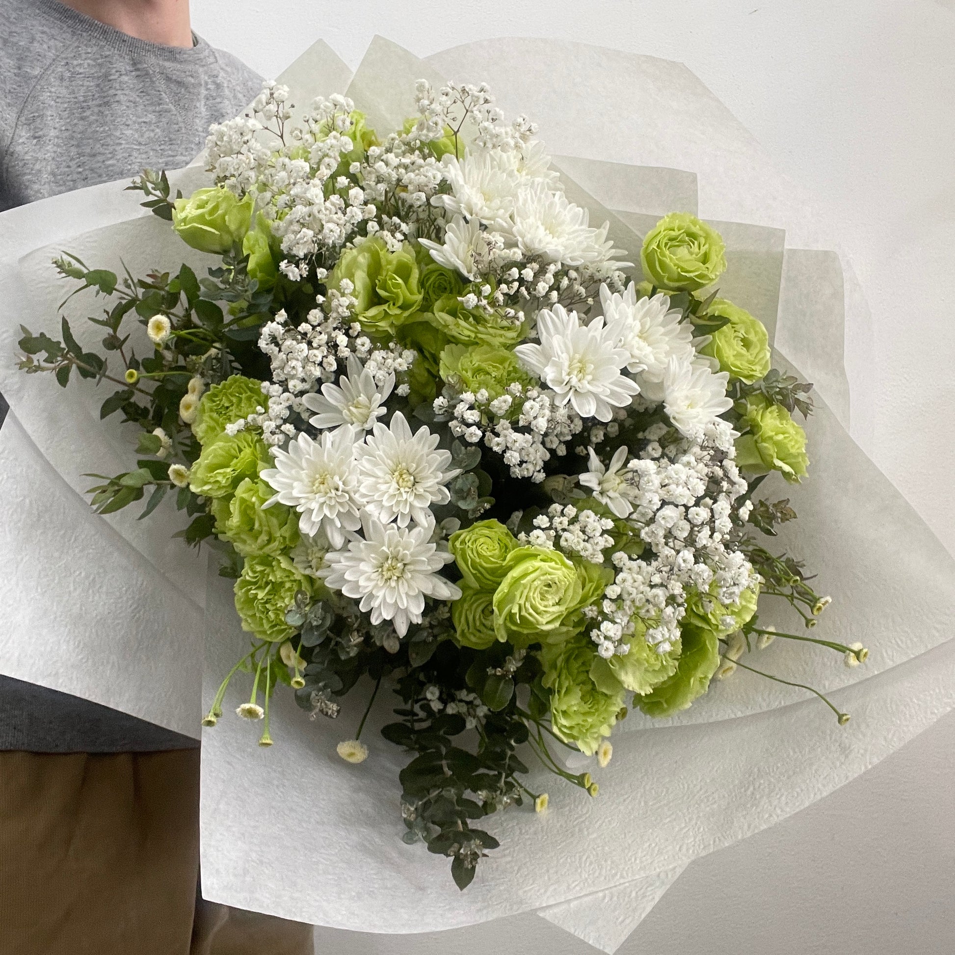 Rounded white and green bouquet featuring chrysanthemums, green carnations, lisianthus, and baby’s breath, made by Adam The Flower Man in Sandringham.