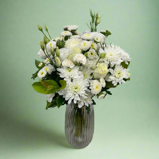 White and green seasonal flower bouquet wrapped in signature paper and ribbon, showcasing fresh summer blooms.