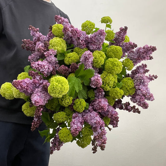Large rounded lilac and green bouquet featuring viburnum snowball and purple blooms, made by Adam The Flower Man in Sandringham.