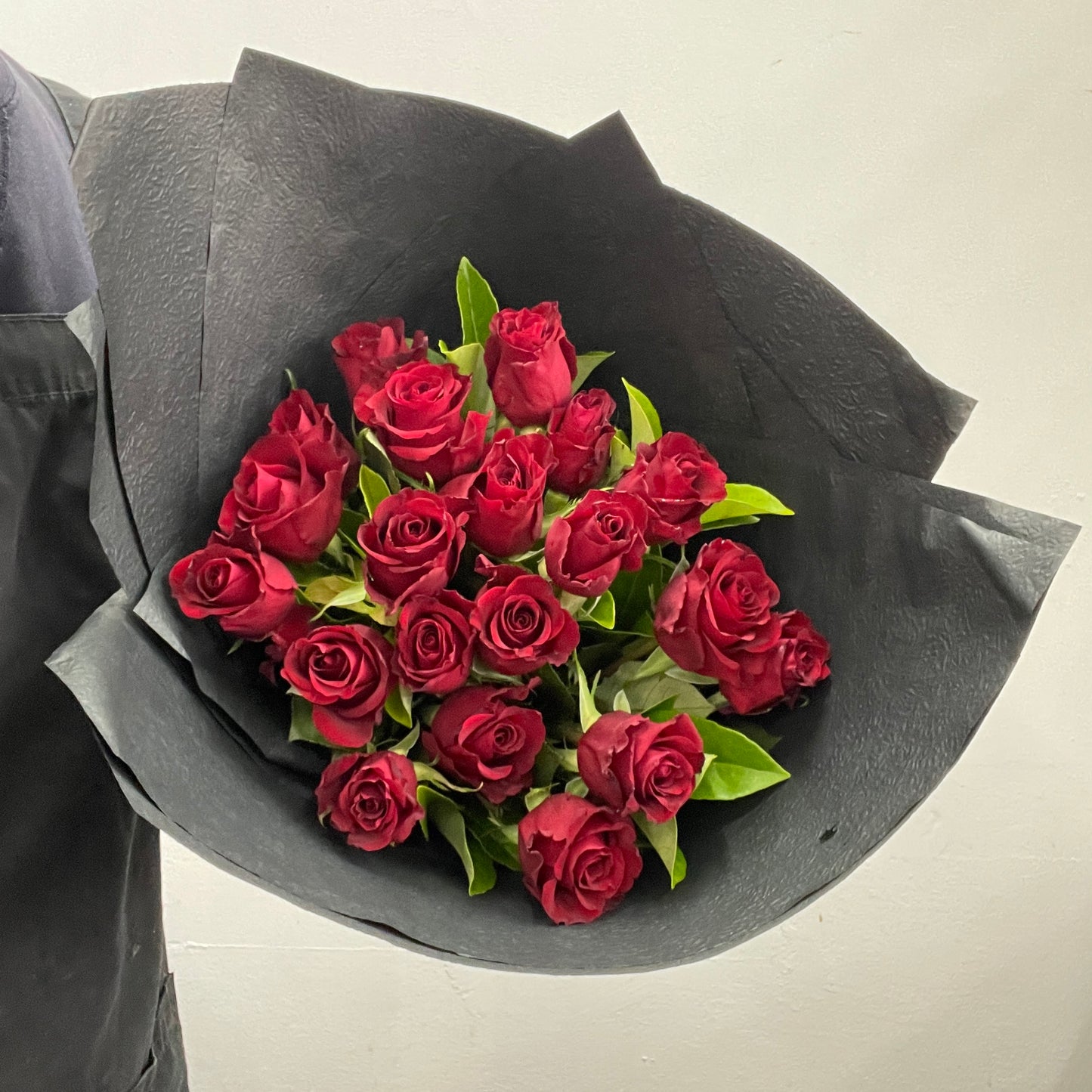 Rounded bouquet featuring red roses and viburnum foliage in red and green tones, part of the Spring Limited Collection 2025 by Adam The Flower Man.